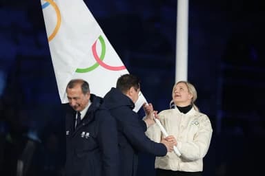 IOC President Kirsty Coventry holding the Olympic flag during an official Olympic ceremony, illustrating the new female-category eligibility policy