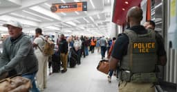 ICE agents in tactical vests patrol a terminal at a US airport during the DHS partial government shutdown, March 2026