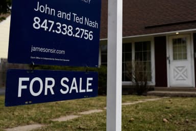 A residential for-sale sign in front of a U.S. home, illustrating the housing market context for Fannie Mae-backed mortgages