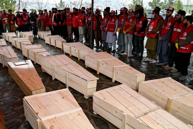 Afghan Red Crescent volunteers carry coffins during a mass funeral in Kabul for victims of the rehabilitation centre strike, March 2026