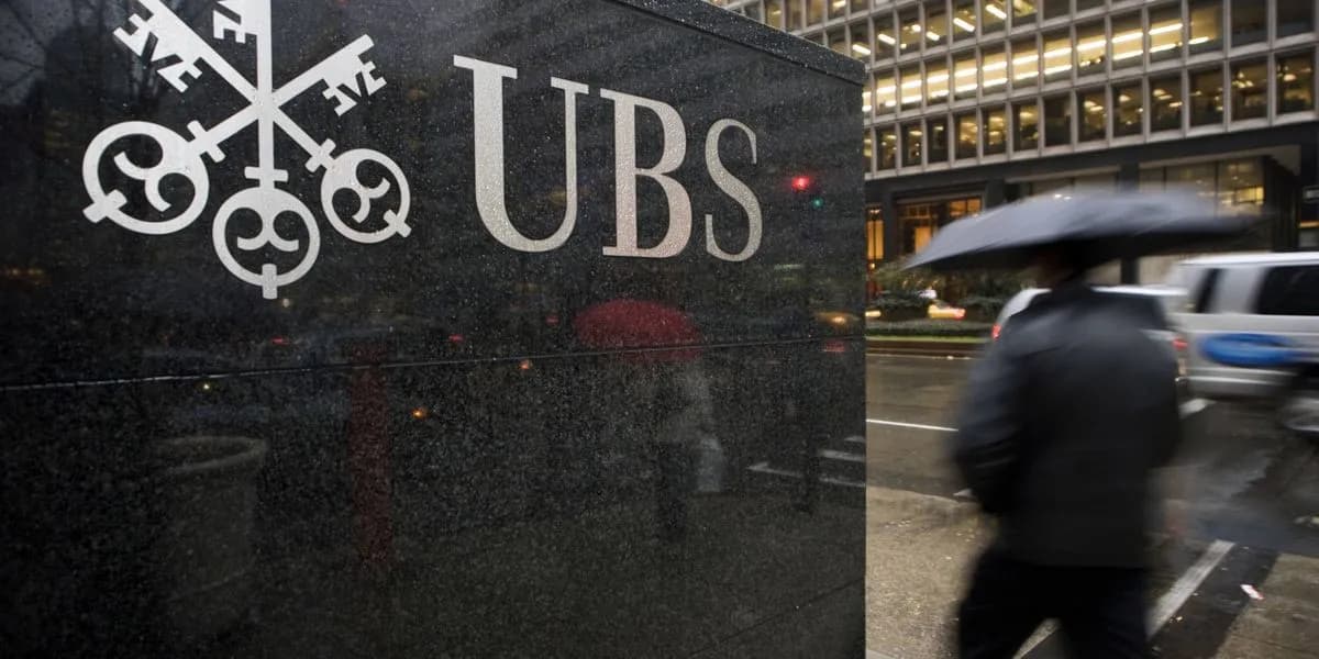 A pedestrian walks past the UBS headquarters on Park Avenue in New York City, with the UBS logo prominently displayed on the building facade