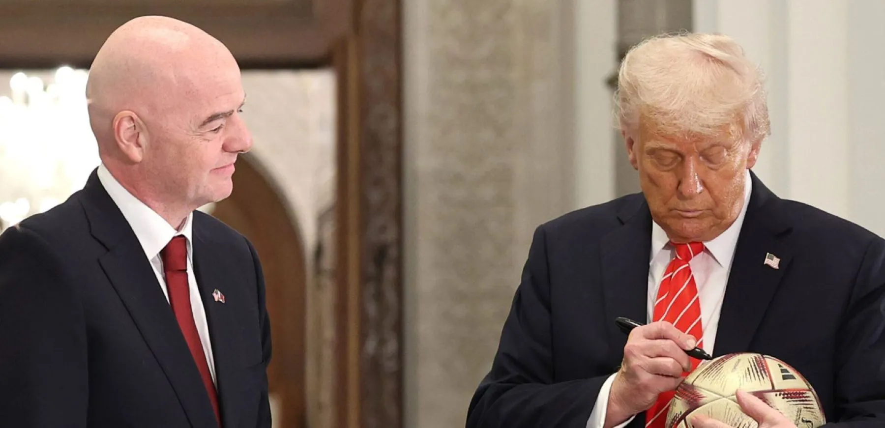 FIFA president Gianni Infantino and U.S. President Donald Trump sign a football during a 2026 World Cup ceremony in Doha in May 2025.