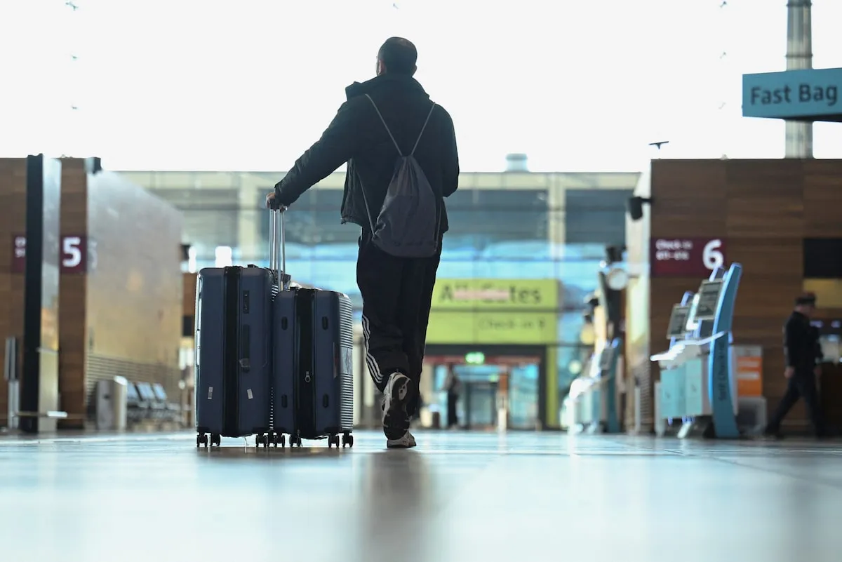 A lone passenger walks through an empty departure terminal at Berlin Brandenburg Airport during a Verdi union strike