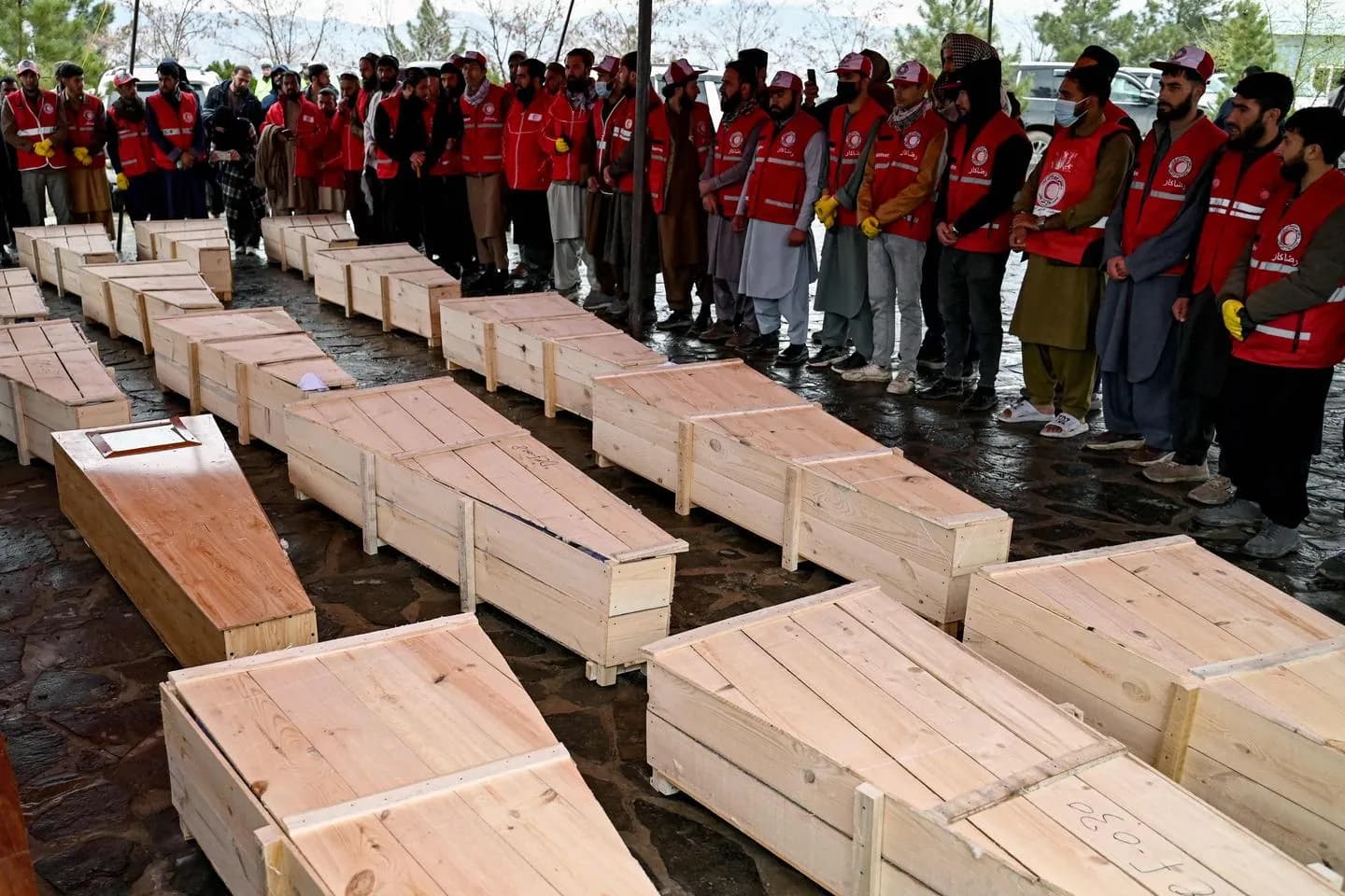 Afghan Red Crescent volunteers carry coffins during a mass funeral in Kabul for victims of the rehabilitation centre strike, March 2026