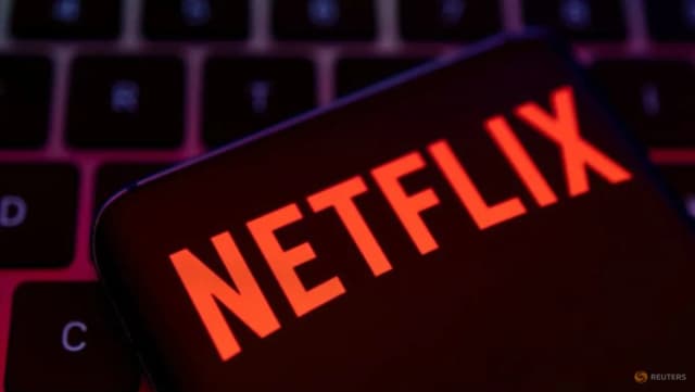 A smartphone displaying the Netflix logo rests on a keyboard in a Reuters illustration about Netflix's U.S. subscription price increase