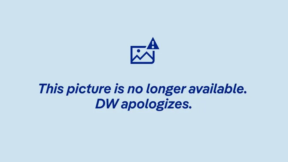 A woman wearing a burkini walks into the water at a public swimming area