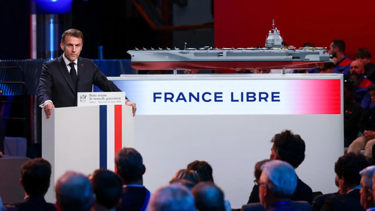 President Emmanuel Macron stands next to a model of the future France Libre aircraft carrier during the naming ceremony in Nantes, western France, March 18, 2026