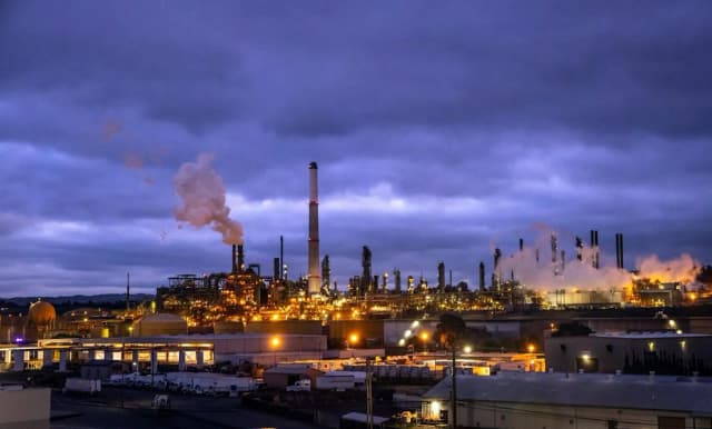 Ein industrieller Raffineriekomplex mit großen Lagertanks und Verarbeitungseinheiten, der das schrumpfende Raffineriepolster hinter Kaliforniens Flugkraftstoffknappheit illustriert.