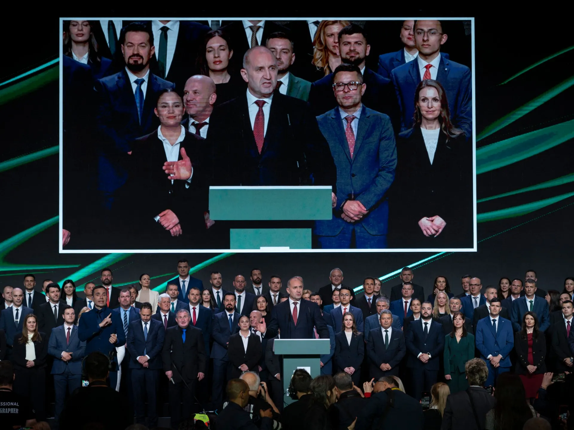 Former Bulgarian president Rumen Radev speaks on a large screen above supporters at a Progressive Bulgaria campaign event in Sofia.