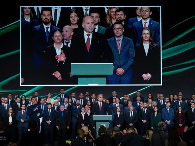 Former Bulgarian president Rumen Radev speaks on a large screen above supporters at a Progressive Bulgaria campaign event in Sofia.