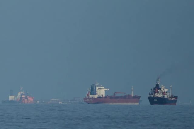 Oil tankers and cargo ships line up in the Strait of Hormuz near Khor Fakkan in the United Arab Emirates in a file AP photo.