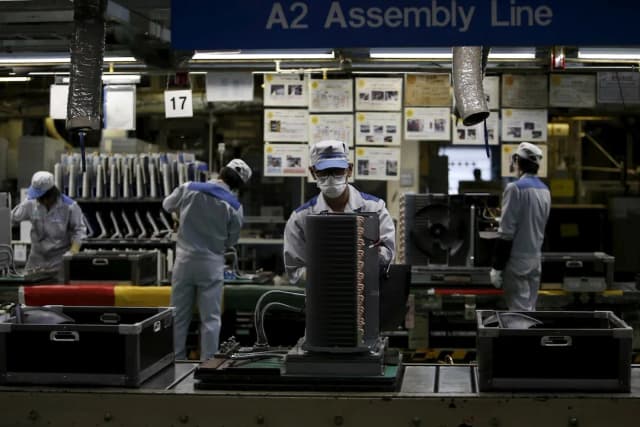 Workers on a Daikin air-conditioner production line at the company's Kusatsu factory in Shiga prefecture, Japan