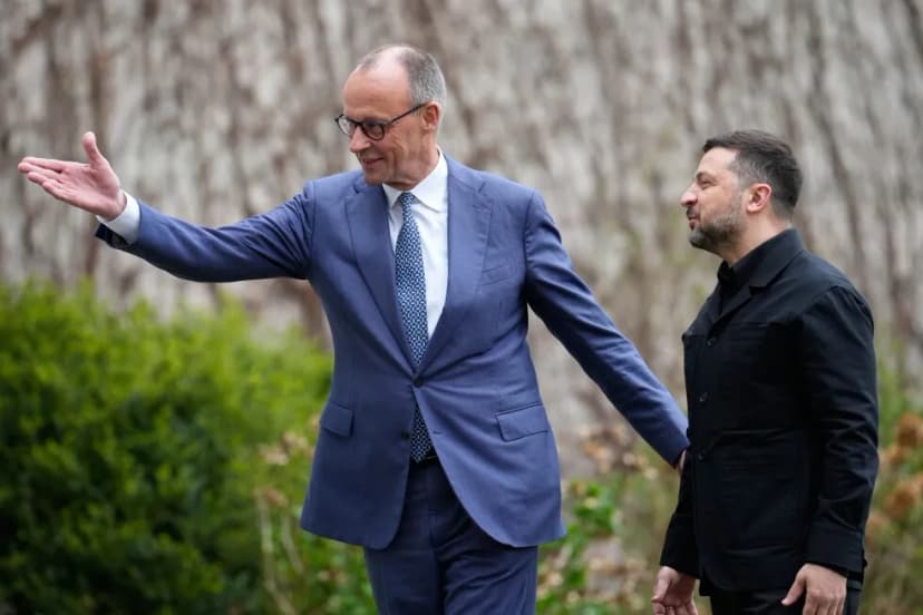 Friedrich Merz shakes hands with Volodymyr Zelenskyy outdoors in Berlin.