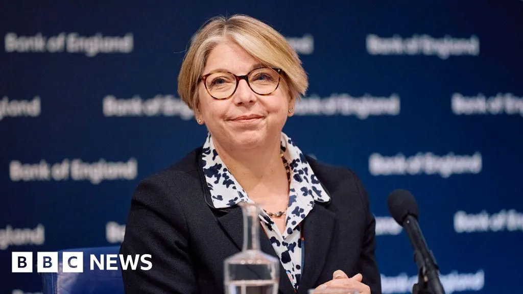 Sarah Breeden sits at a Bank of England event in a dark jacket and patterned scarf.