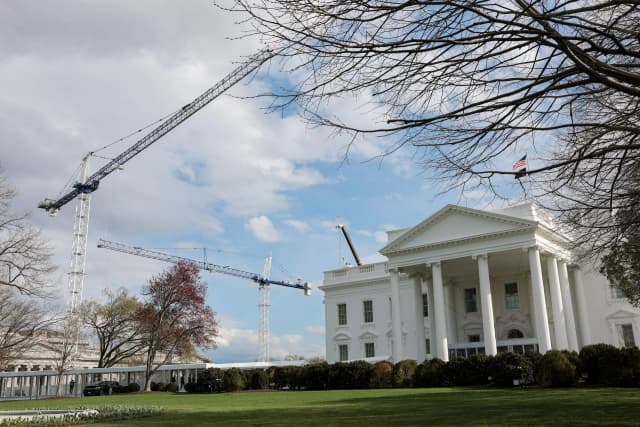 Construction cranes work over the White House East Wing renovation site in Washington, D.C., on March 17, 2026, as Donald Trump’s ballroom project faces a court-ordered halt.