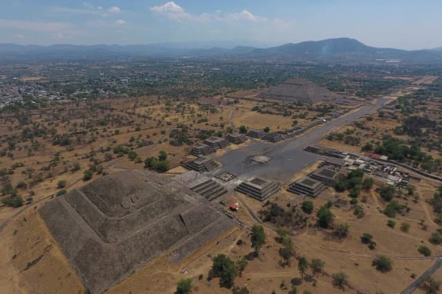 Forensic workers carry a body down steps near the Teotihuacan pyramids after the shooting in Mexico.