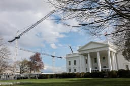 Construction cranes work over the White House East Wing renovation site in Washington, D.C., on March 17, 2026, as Donald Trump’s ballroom project faces a court-ordered halt.