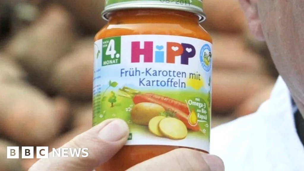 A person holds a jar of HiPP baby food, used to illustrate the Austria recall of jars sold through Spar supermarkets.