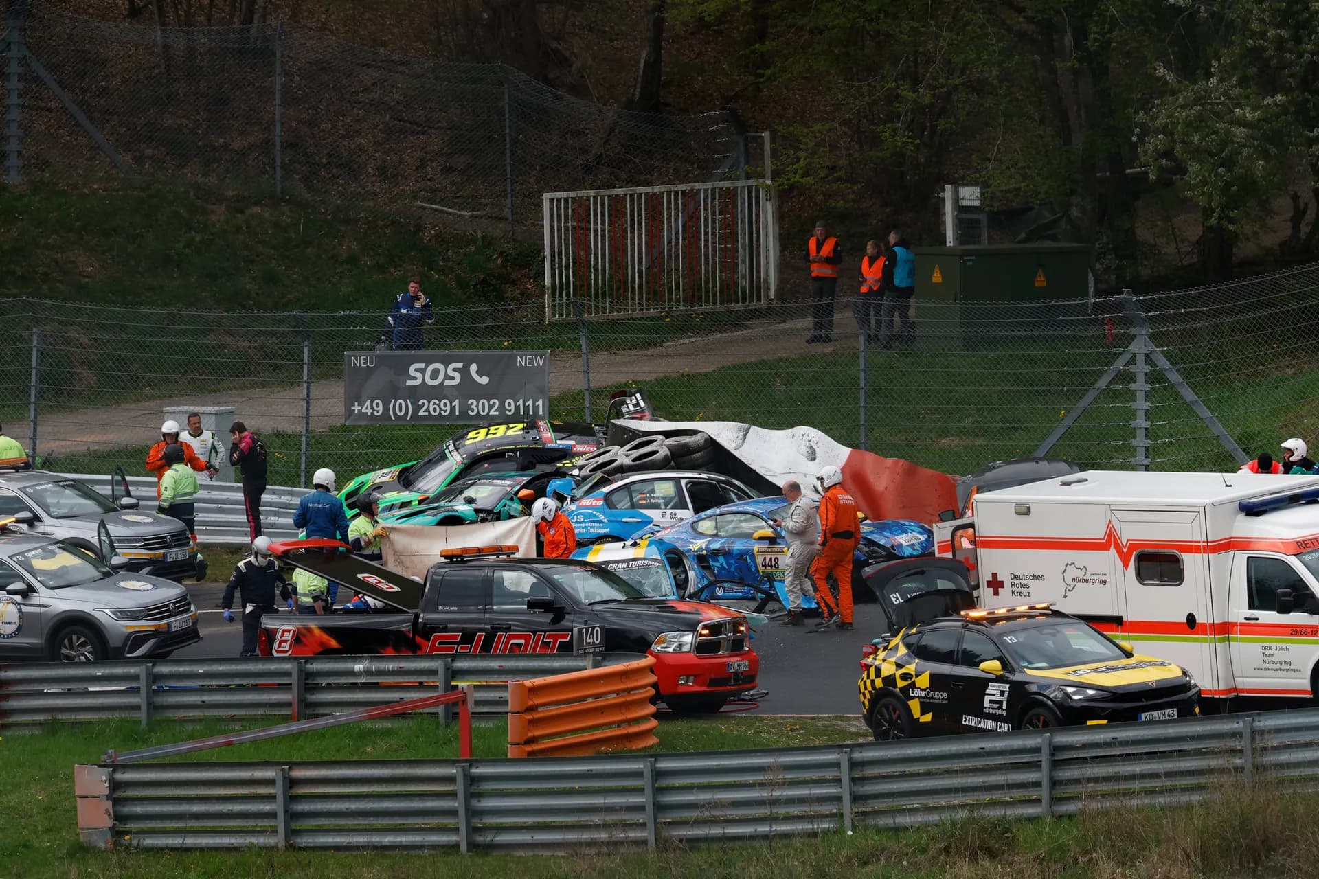 Emergency vehicles and damaged race cars are seen after a multi-car crash during the Nürburgring qualifier.
