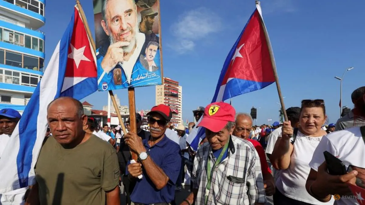 People carry Cuban flags and portraits of Fidel Castro during a May Day rally in Havana in a Reuters photo by Claudia Daut.