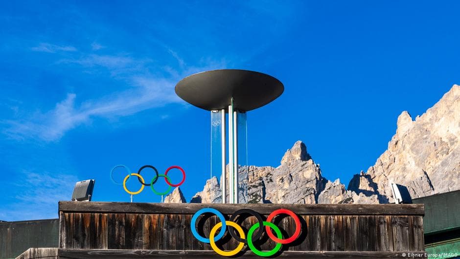 The Milan-Cortina 2026 Winter Olympics logo and Olympic rings displayed at a competition venue in northern Italy