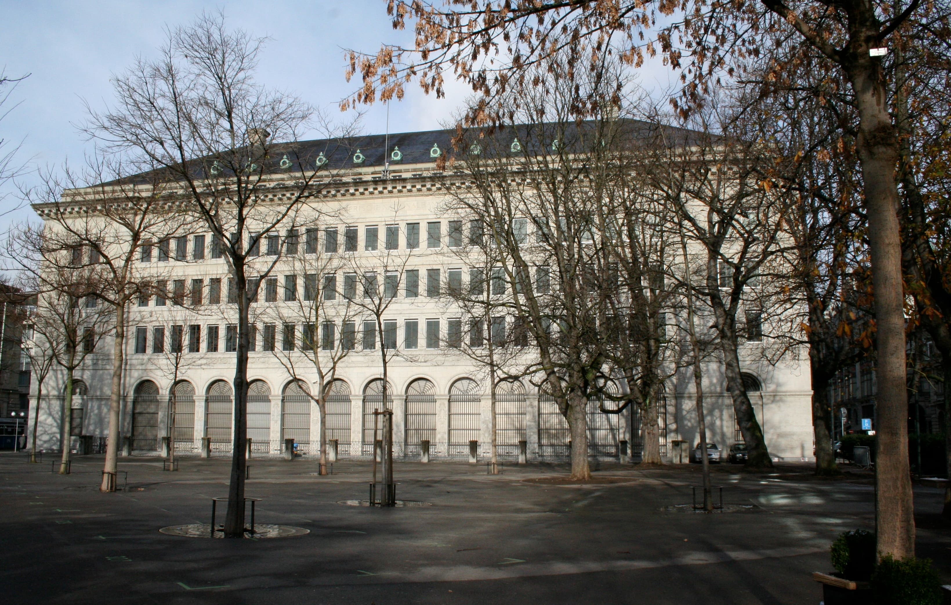 A grand stone building housing the Swiss National Bank in Zurich, photographed from street level