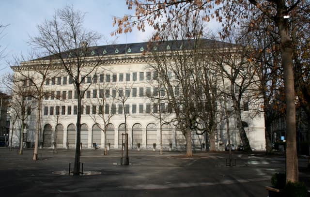 A grand stone building housing the Swiss National Bank in Zurich, photographed from street level