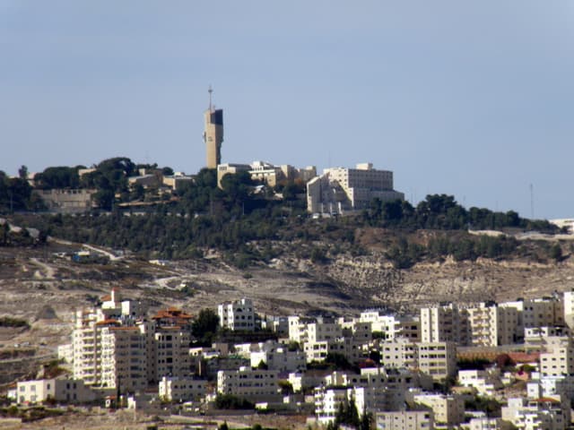 Aerial view of a large Israeli settlement built on hillside terrain in the occupied West Bank