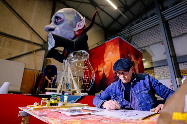 A large colourful carnival float under construction in a workshop ahead of the Rose Monday parade in Cologne