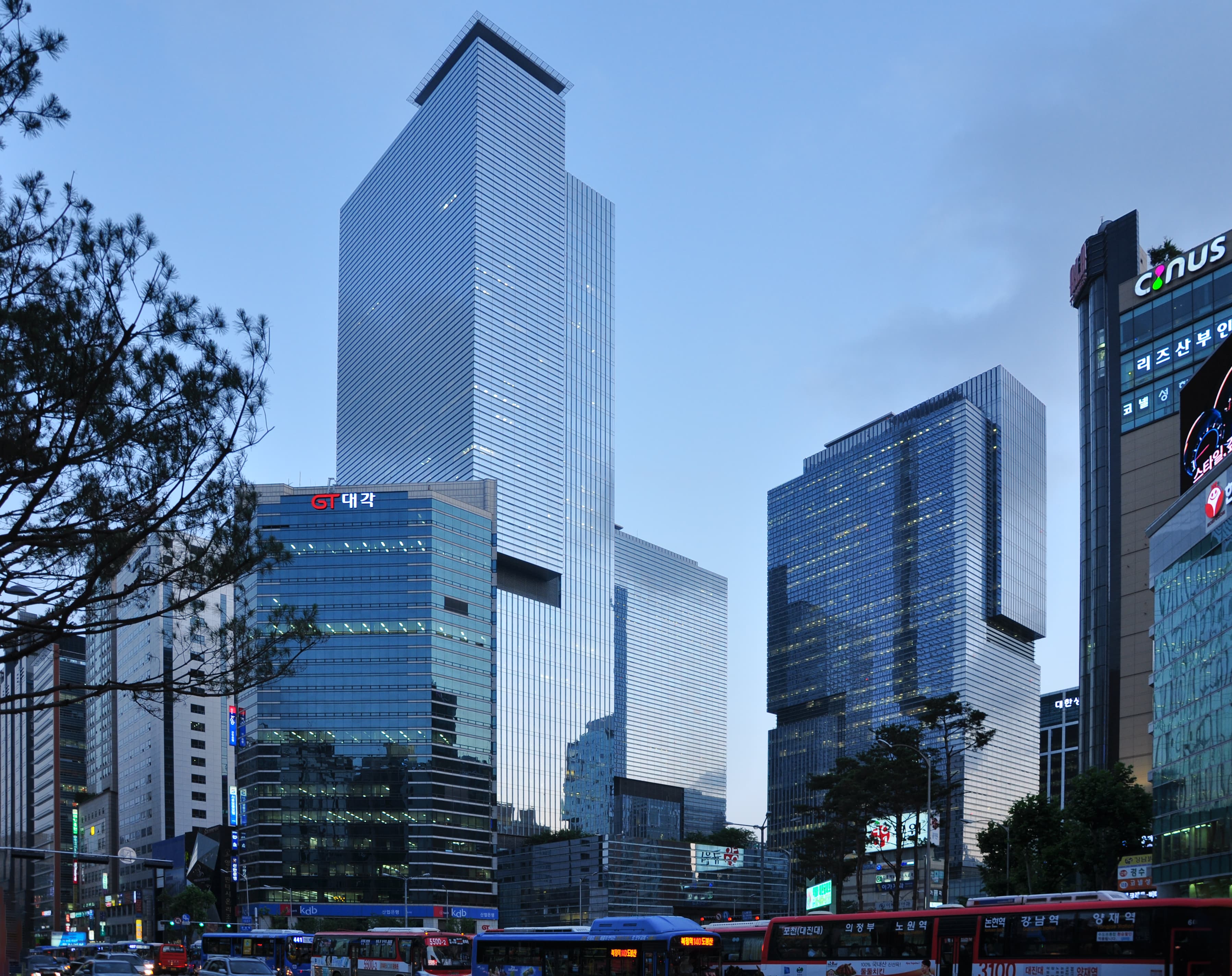 A modern corporate headquarters building with curved glass facade and landscaped grounds