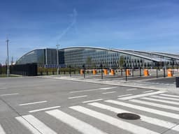 The new NATO headquarters building in Brussels, a modern glass and steel structure seen from an exterior viewpoint