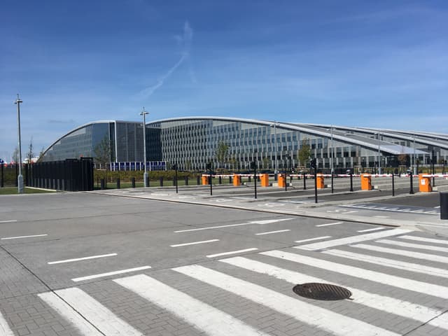 The new NATO headquarters building in Brussels, a modern glass and steel structure seen from an exterior viewpoint