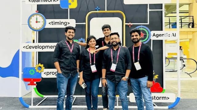 A group of Astreya staff members posing in front of a trade-show display featuring software-development and AI signage