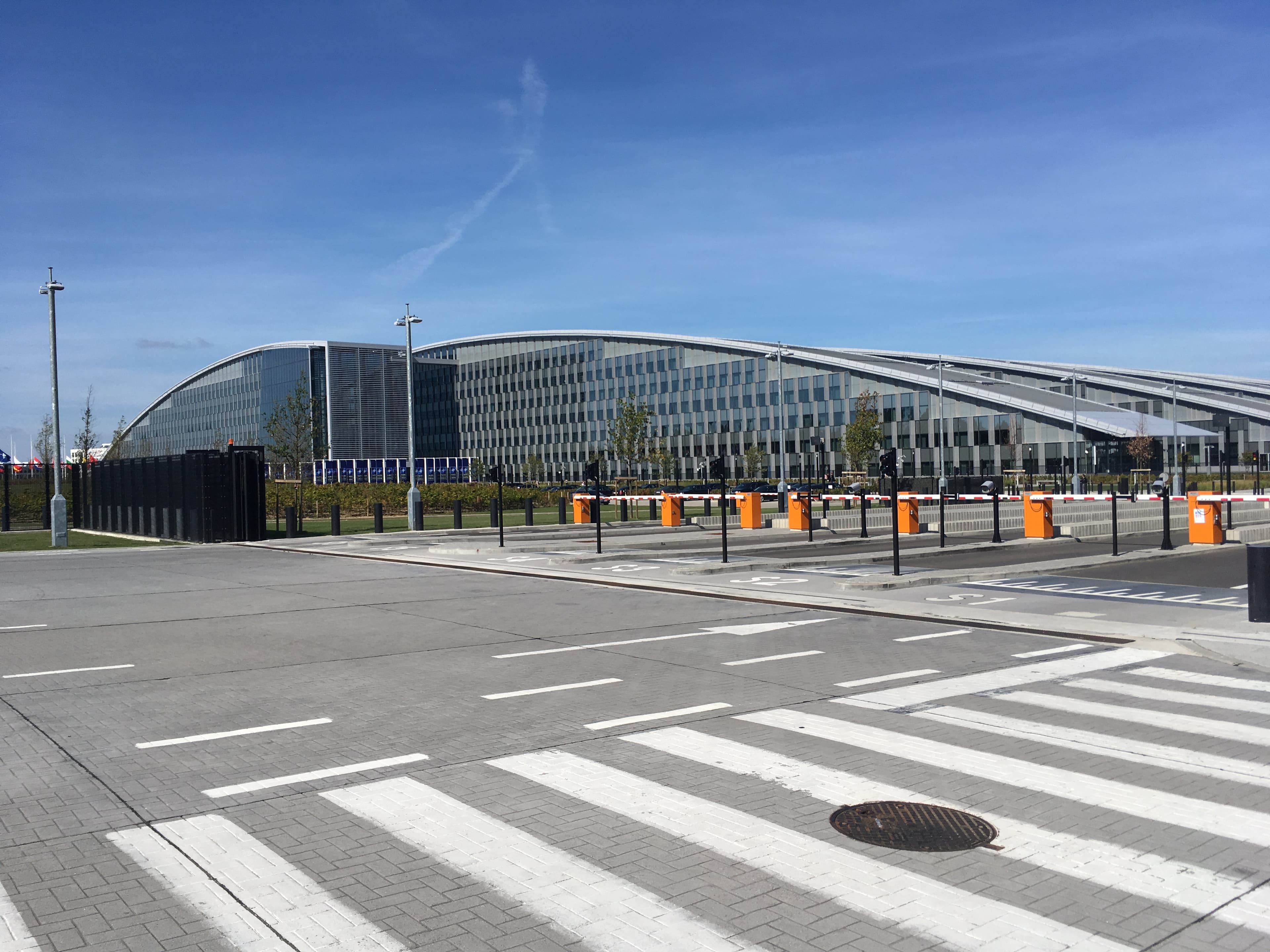 The new NATO headquarters building in Brussels, a modern glass and steel structure seen from an exterior viewpoint